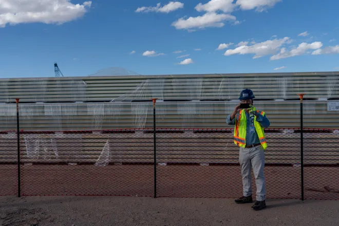 An employee with Oracle stands near construction equipment during a media tour of Project Jupiter in Santa Teresa, N.M., on Tuesday, Oct. 13, 2026. The equipment yard was one of three stops visited by members of the media during the tour of the data center campus under construction.