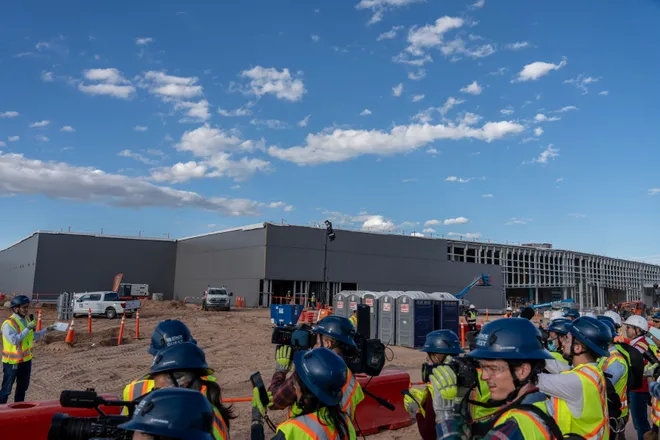 Members of the media listen as Mike Casey, chief operations officer at STACK Infrastructure, speaks during a tour of Project Jupiter in Santa Teresa, N.M., on Tuesday, Oct. 13, 2026. A data center building under construction is seen in the background.