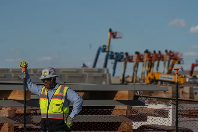 An employee with Oracle observes a media tour from a construction equipment yard at Project Jupiter in Santa Teresa, N.M., on Tuesday, Oct. 13, 2026. The staging area was one of three stops visited by members of the media during a tour of the data center campus under construction.