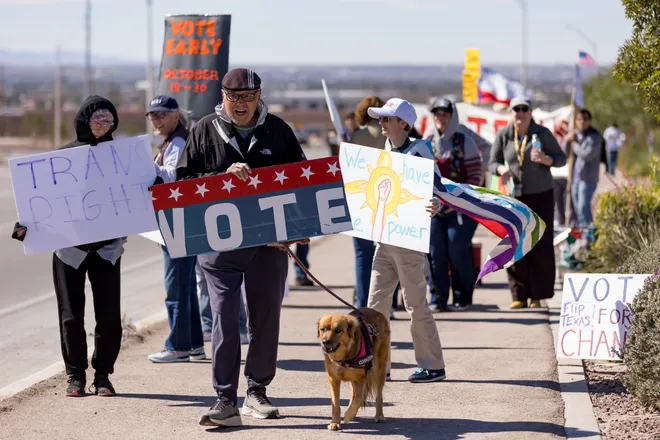 Former state Sen. José Rodríguez holds a “Vote” sign beside a dog along Eastlake Boulevard during a “No Kings” sidewalk protest organized by Indivisible the 915 in El Paso, Texas, on Saturday, Oct. 17, 2026.