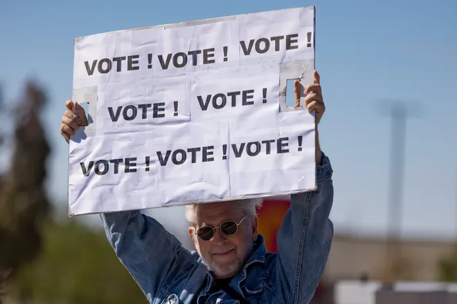 A participant raises a sign repeating the word “Vote!” along Eastlake Boulevard during a “No Kings” sidewalk protest organized by Indivisible the 915 in El Paso, Texas, on Saturday, Oct. 17, 2026.