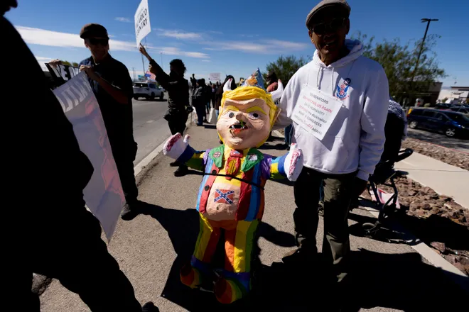 A participant stands beside a piñata of Donald Trump along Eastlake Boulevard during a “No Kings” sidewalk protest organized by Indivisible the 915 in El Paso, Texas, on Saturday, Oct. 17, 2026.