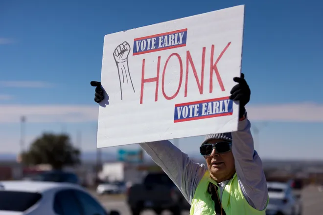 A participant raises a sign reading “Honk” and “Vote early” along Eastlake Boulevard during a “No Kings” sidewalk protest organized by Indivisible the 915 in El Paso, Texas, on Saturday, Oct. 17, 2026.