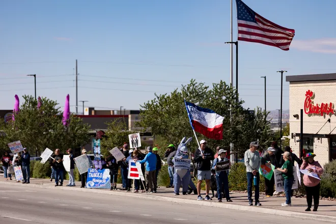 Participants line Eastlake Boulevard with signs and flags during a “No Kings” sidewalk protest organized by Indivisible the 915 in El Paso, Texas, on Saturday, Oct. 17, 2026.