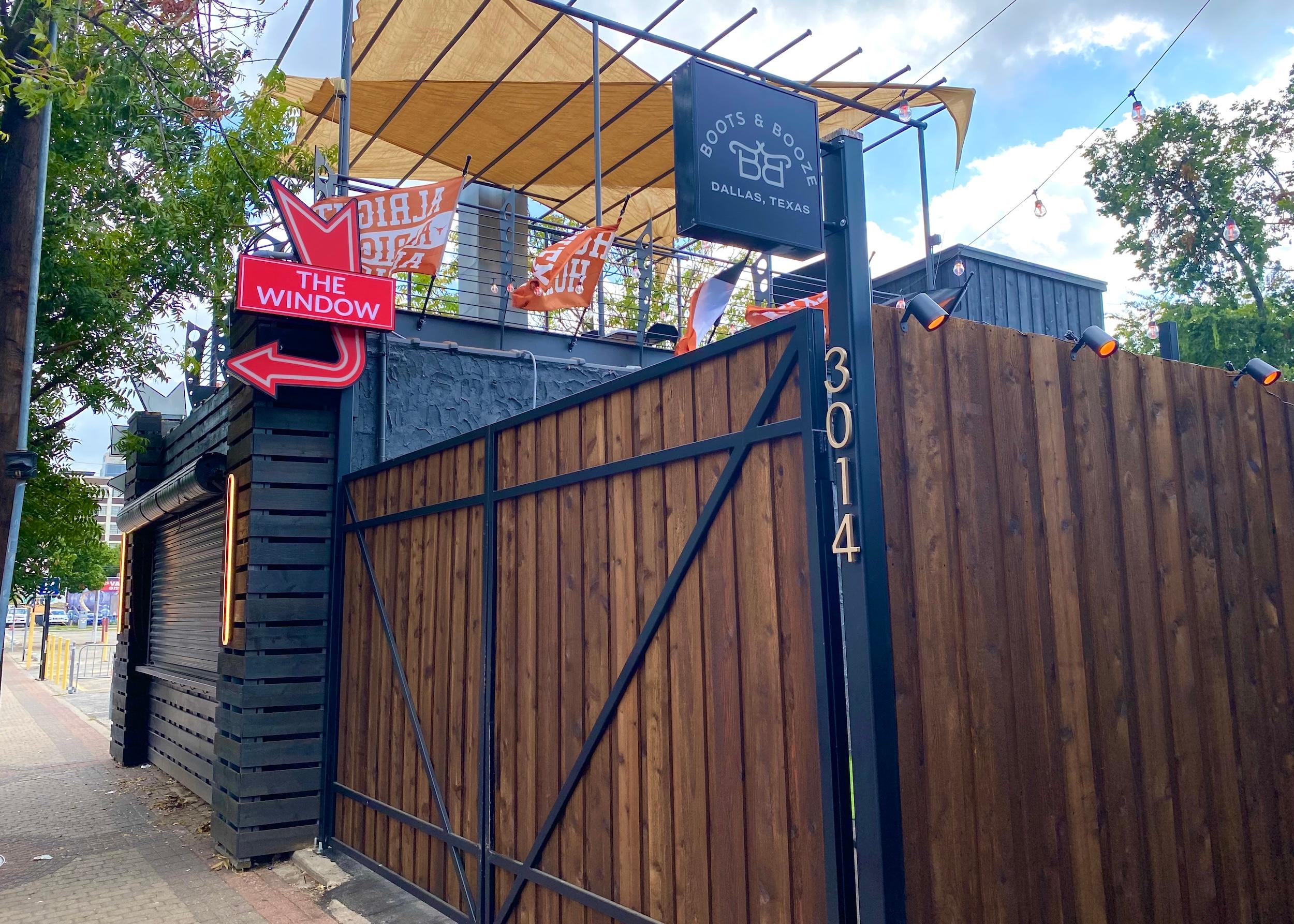 boots and booze sign and fence in deep ellum