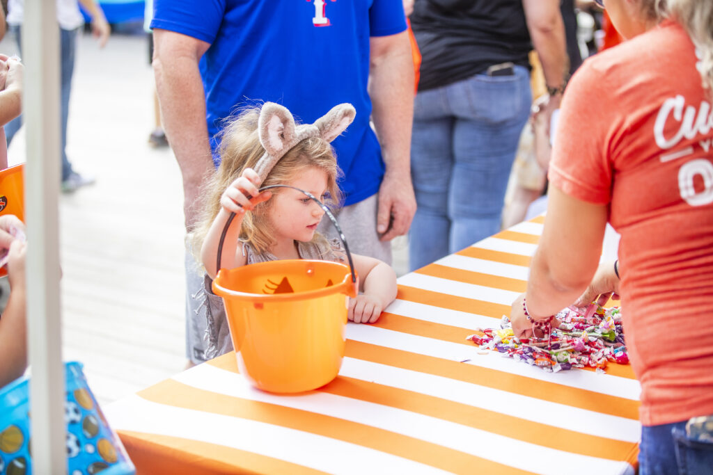 Young girl in bunny ears at Halloween trick-or-treat event.
