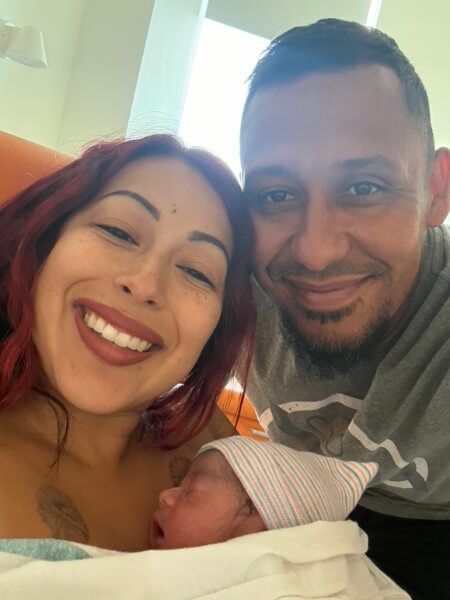 Patient photo of herself, her husband and newborn son in the hospital.