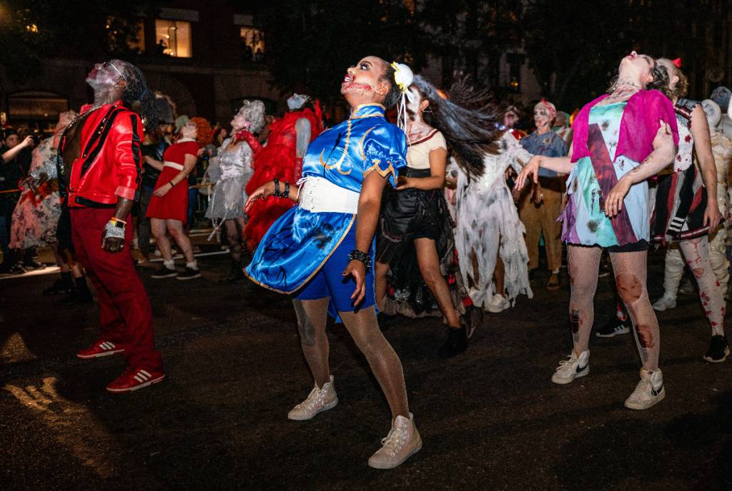 Image shows people dancing at a Halloween street party. 