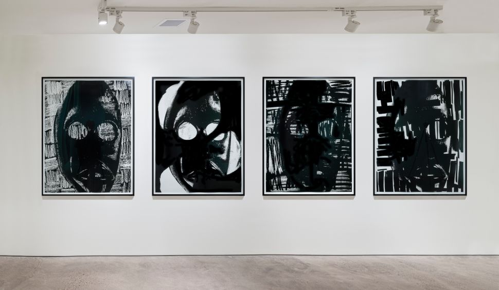 A row of four black-and-white abstract works hangs beneath track lighting on a white wall at Ostillo Art Foundation.