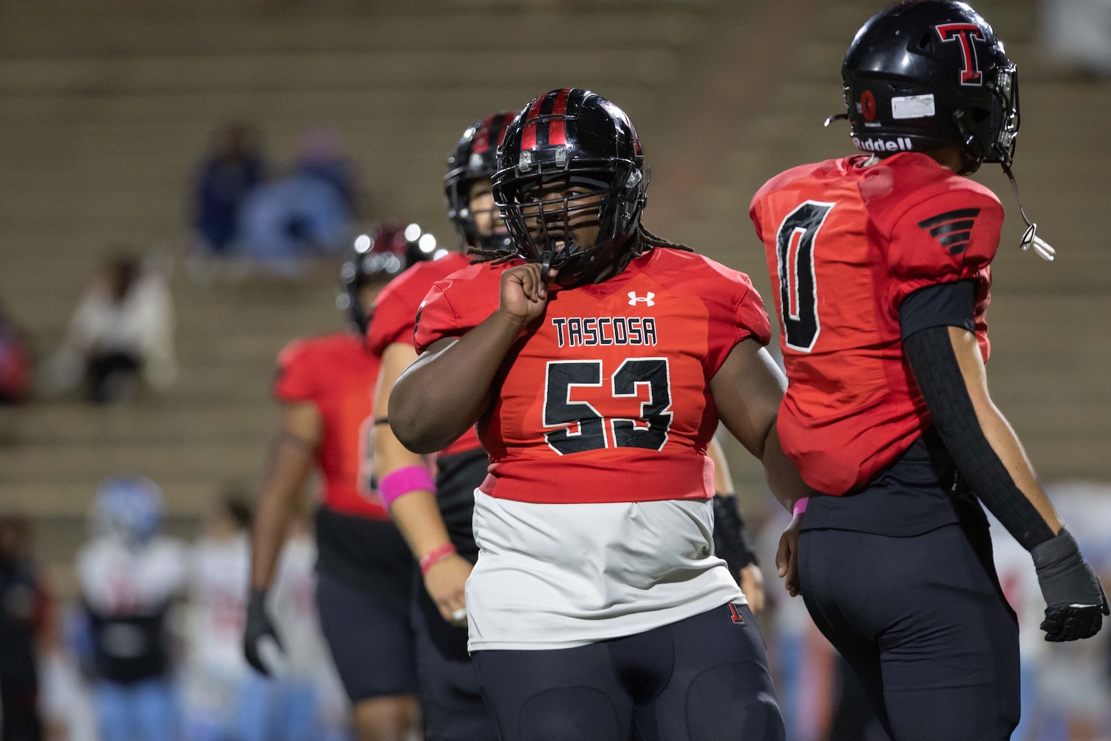 MHS-THS-FB-36 | Press Pass Sports Tascosa football player wearing number 53 in a red jersey blocks on the field, fist raised in a game moment.