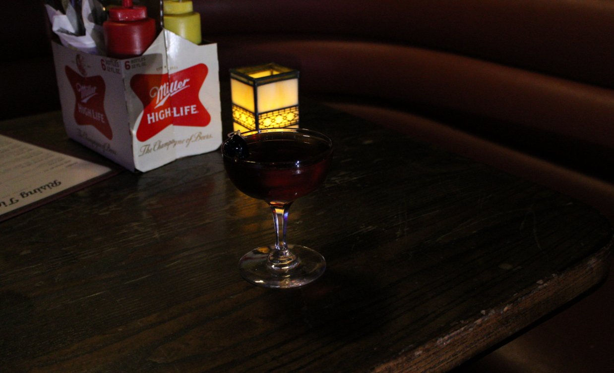 A Malorthattan served with two cherries in a classic martini glass at Rising Tides Bar.