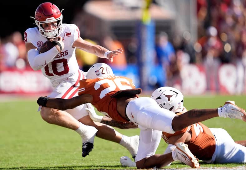 Oklahoma Sooners quarterback John Mateer (10) tries to get by Texas Longhorns linebacker Ty'Anthony Smith (26) in the first half