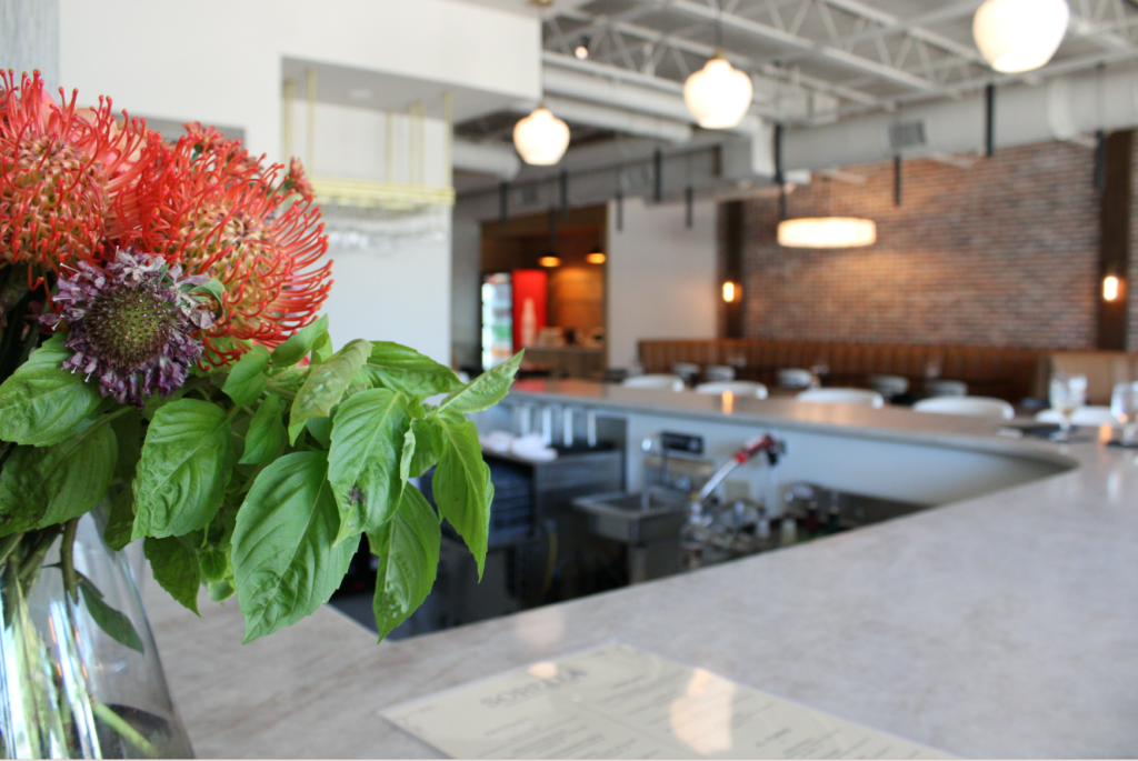 Lotus flowers in focus with the bar and dining room in the background.