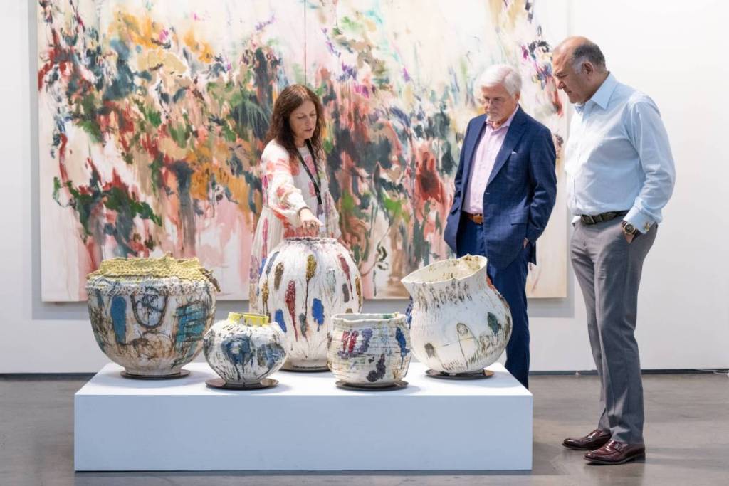 Image shows people admiring ceramic art pieces at Untitled Art, Houston. 