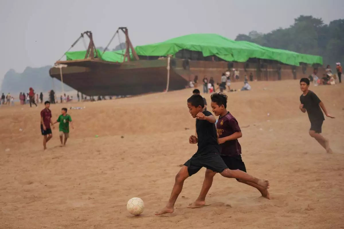 Kids play soccer near a barge stranded on a dry riverbed of the Kapuas River amid a drought in Sekadau, West Kalimantan, Indonesia, Friday, Sept. 11, 2026. (AP Photo/Tatan Syuflana)