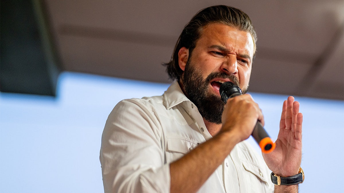 Texas Republican House candidate Brandon Herrera speaking into a microphone