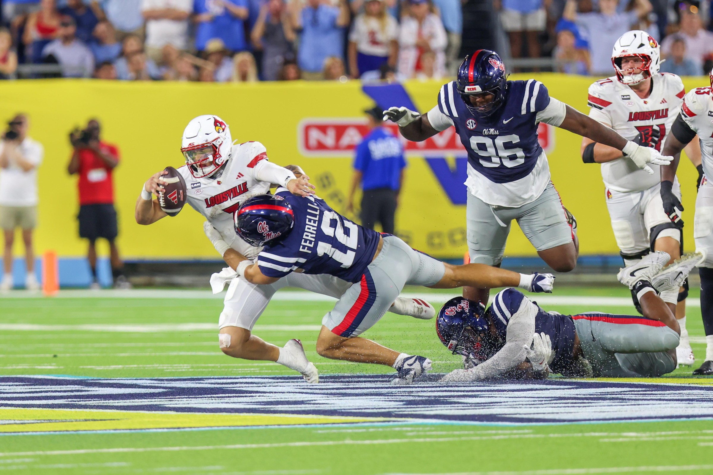 NASHVILLE, TENNESSEE - SEPTEMBER 6: Lincoln Kienholz #3 of the Louisville Cardinals is tackled by Luke Ferrelli #12 of the Ole Miss Rebels during a game between the Ole Miss Rebels and the Louisville Cardinals at Nissan Stadium on September 6, 2026 in Nashville, Tennessee. (Photo by Roger Wimmer/ISI Photos/ISI Photos via Getty Images)