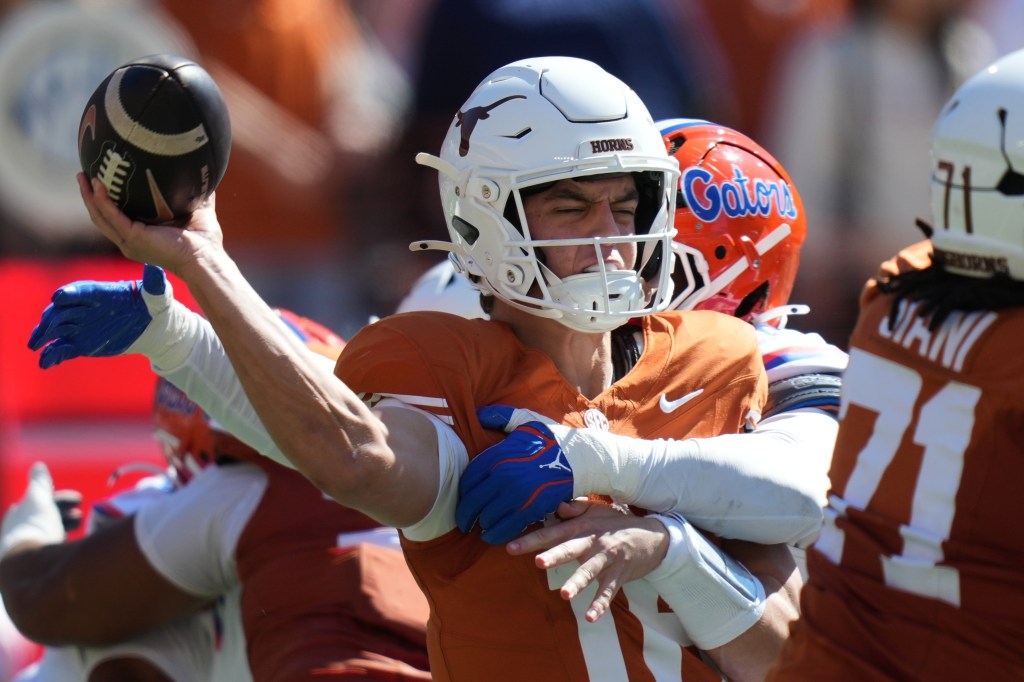 Texas quarterback Arch Manning is hit by Florida linebacker Jaden Robinson as he throws during a college football game.