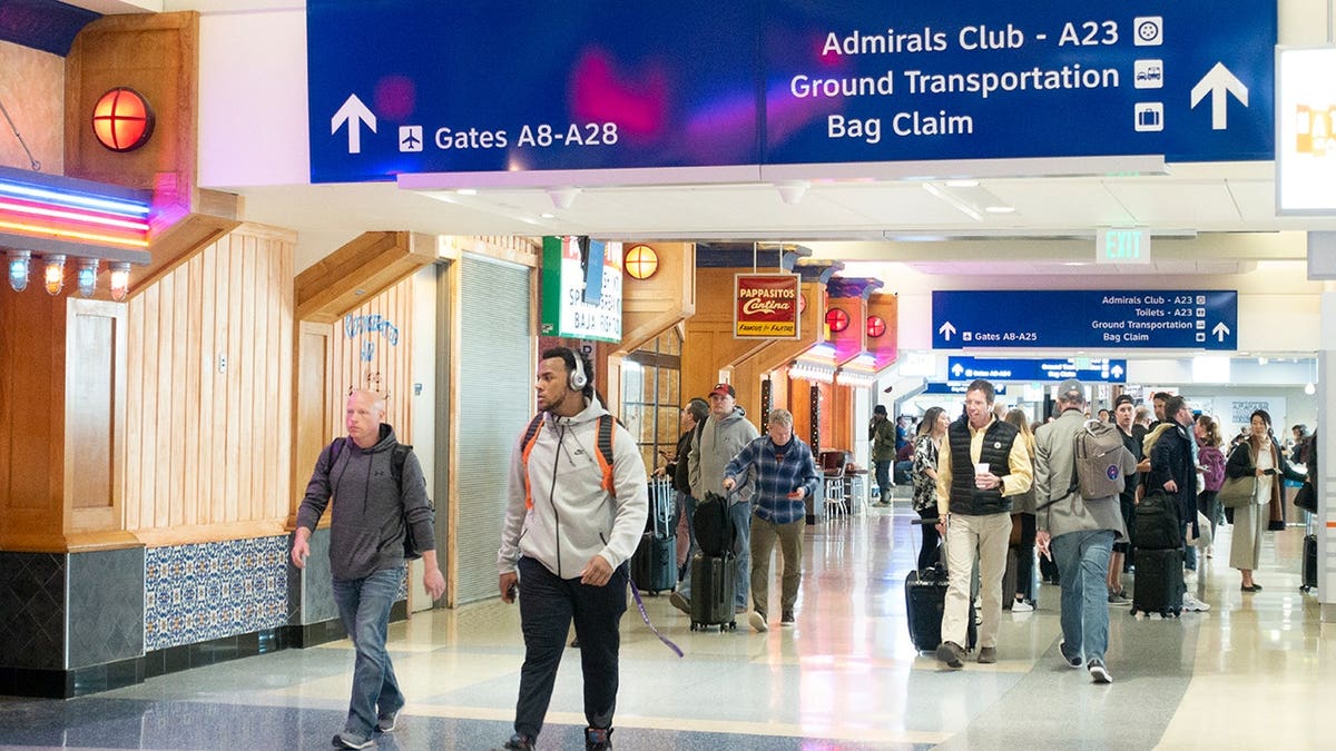 Passengers walk inside a terminal at Dallas Fort Worth International Airport.