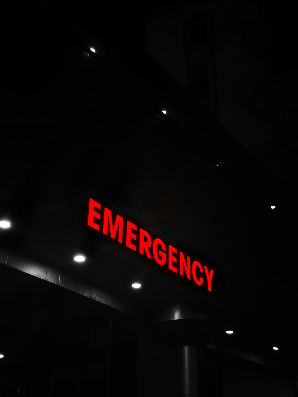Red emergency sign illuminates a dark building entrance