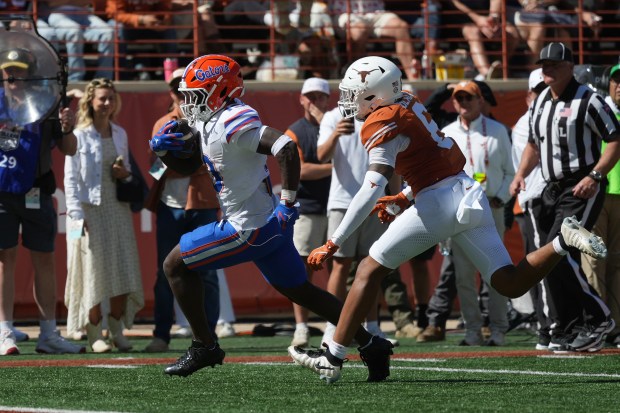 Florida running back Jadan Baugh (13) runs past Texas defensive back Kobe Black (6) for an 11-yard touchdown during the Gators' 27-24 win at Texas Saturday in Austin. (AP Photo/Eric Gay)