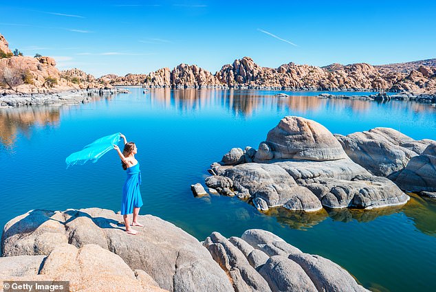 A stock photograph of a woman expressing freedom at Watson Lake, Prescott, Arizona