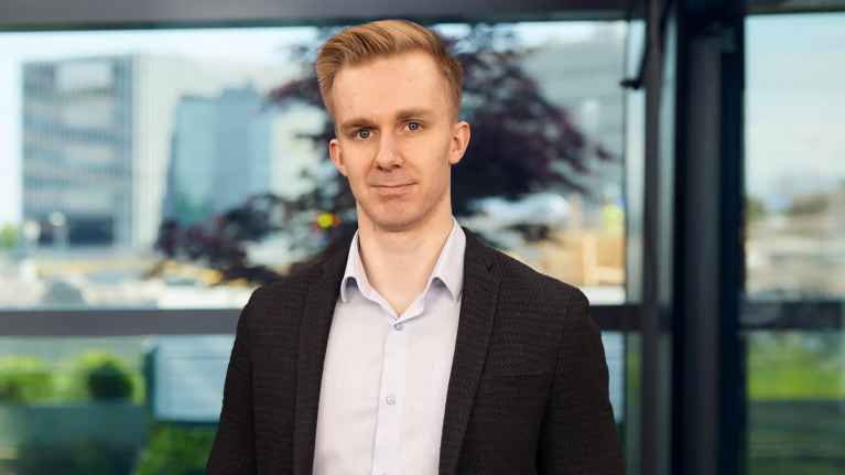 A man looks at the camera in a suit jacket.