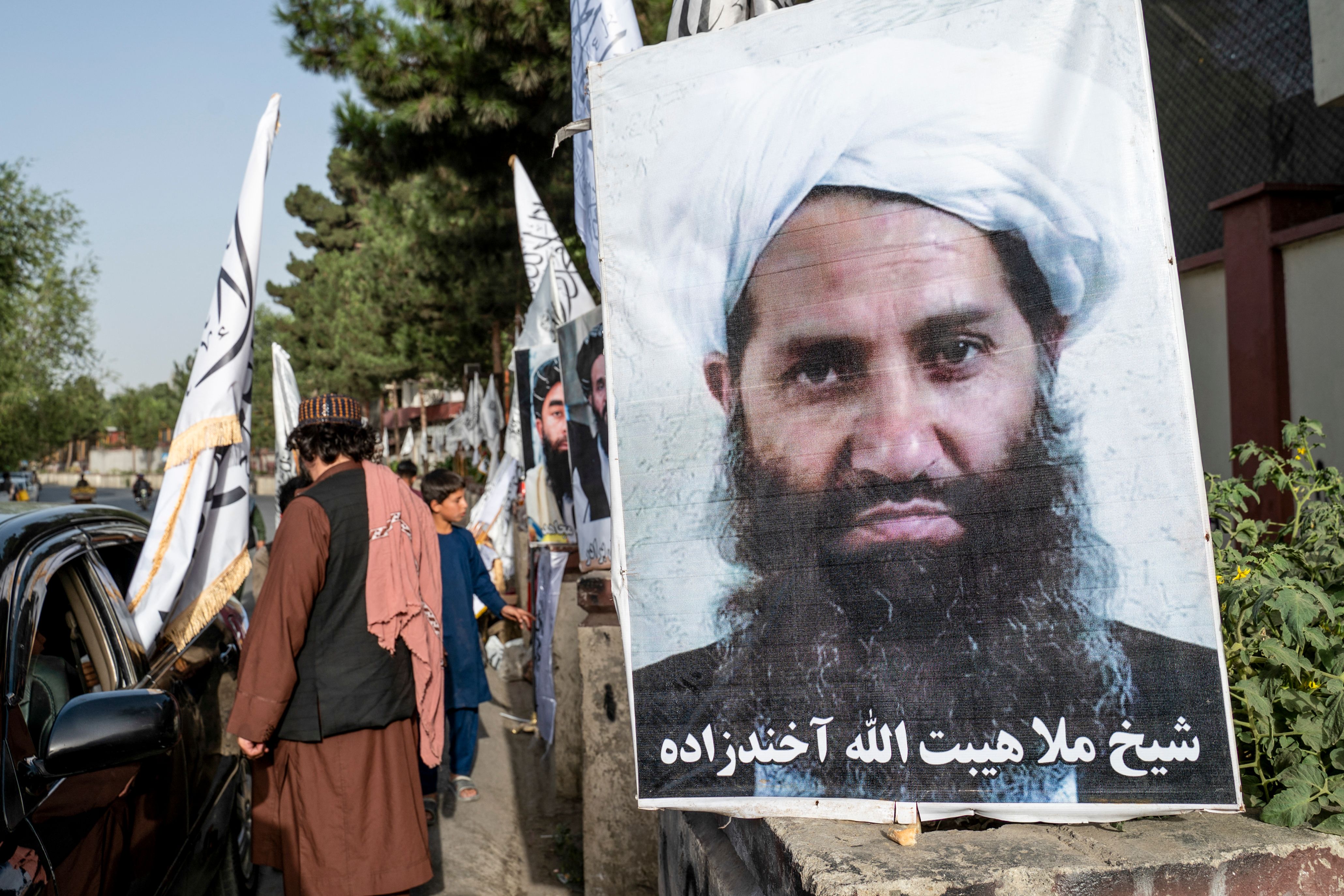 A poster of Taliban Supreme Leader Hibatullah Akhundzada is seen along a road in Kabul on August 14, 2023.
