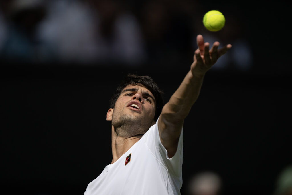 Carlos Alcaraz of Spain serves against Fabio Fognini of Italy (not pictured) during their Gentlemen's Singles first round match on day one of The Championships Wimbledon 2025 at All England Lawn Tennis and Croquet Club on June 30, 2025 in London, England.
