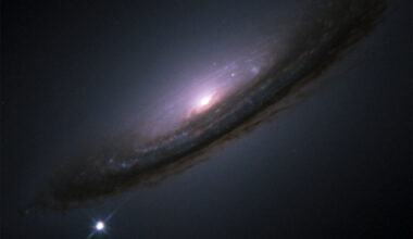 A white dot with diffraction spikes appears near a large swirling galaxy with a bright core.