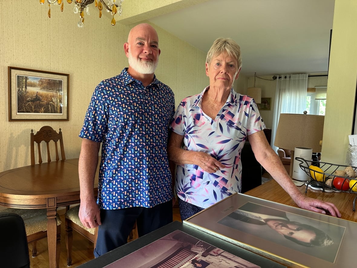 A bald man standing next to a woman.