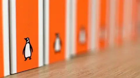 Getty Images The spines of several orange Penguin paperback books are on a shelf. Only the one nearest the camera is in focus. The Penguin logo can be seen on each.