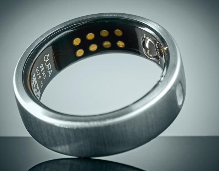 Chrome colored ring on its edge with Oura logo and electronics showing on the inner surface