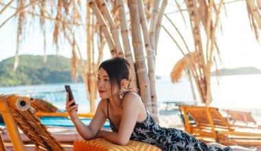 Three friends, with the sunset as their backdrop, taking selfies with their smartphones.