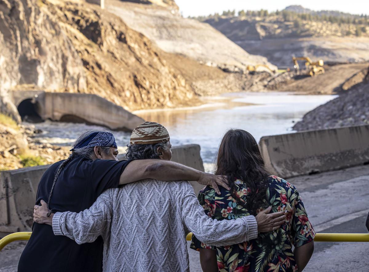 The Hillman family hugs, while watching a construction crew dismantle Iron Gate Dam
