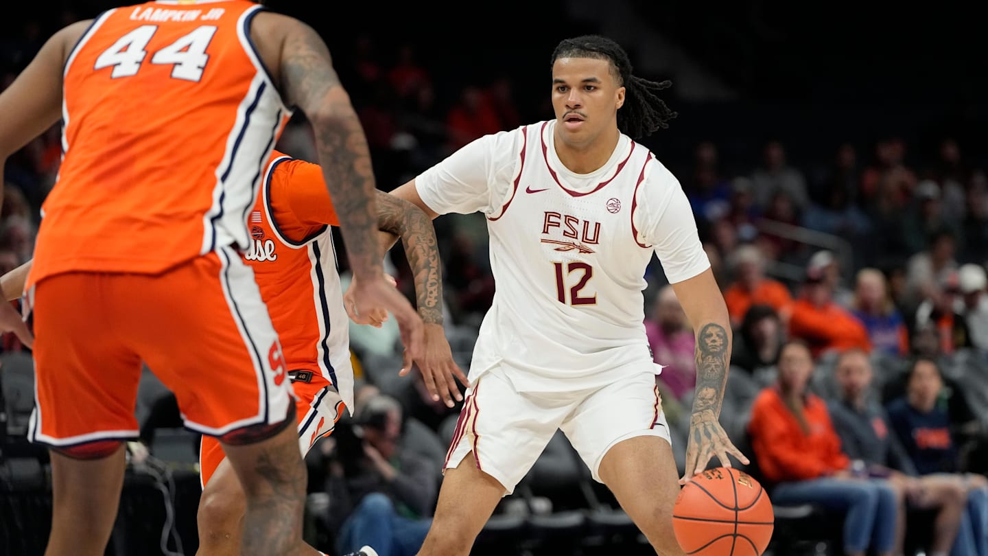 Mar 11, 2025; Charlotte, NC, USA; Florida State Seminoles forward Malique Ewin (12) with the ball as Syracuse Orange center Eddie Lampkin Jr. (44) defends in the first half at Spectrum Center. Mandatory Credit: Bob Donnan-Imagn Images