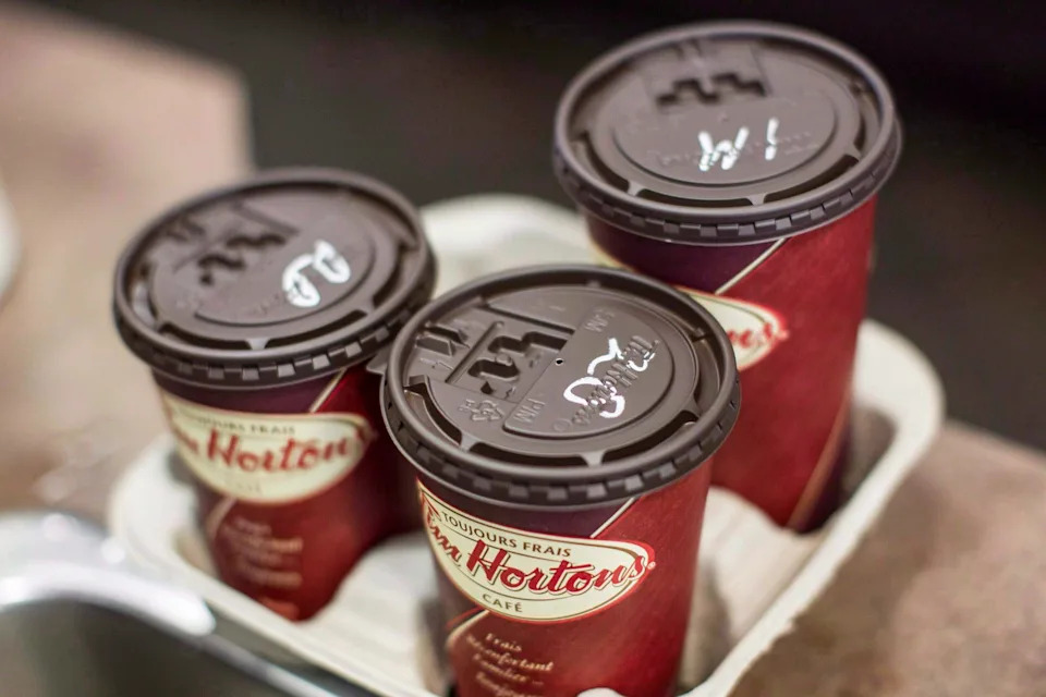 Cups of coffee sit on a counter in a Tim Hortons outlet in Oakville, Ont. on Monday Sept. 16, 2013. Ads for pipeline giant Enbridge will no longer be seen by Canadians waiting in line for double-doubles and Timbits. The spots had been airing for close to three weeks on screens at more than 1,500 Tim Hortons locations between British Columbia and Ontario. THE CANADIAN PRESS/Chris Young