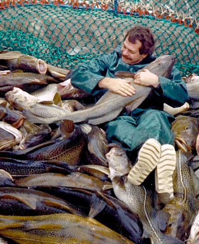 Left: A scientist holds a mature cod in 1987. Right: Biologist Kwi Young Han holding a mature cod today.