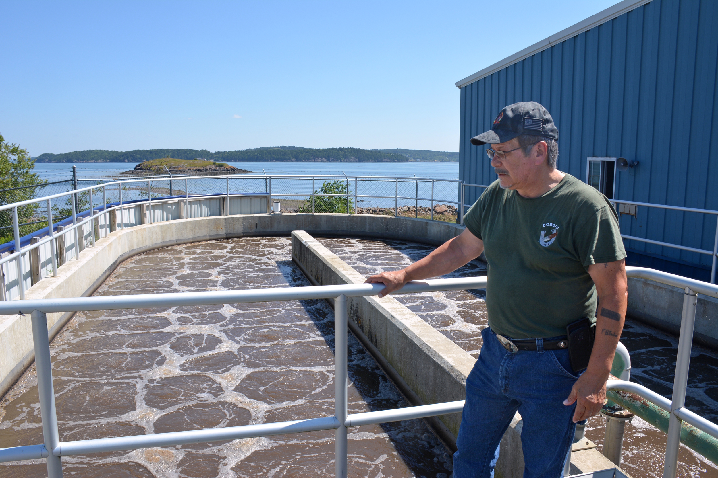 Gene Francis Sr., a retired superintendent of the Passamaquoddy Wastewater Facility, explains how sewage is handled at the facility. The microbes used to treat sewage would be killed if seawater intruded during a flood. Credit: Sydney Cromwell/Inside Climate News