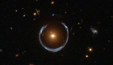 This Hubble Space Telescope image shows the Cosmic Horseshoe gravitational lens. The newly discovered ultramassive blackhole lies at the centre of the orange galaxy. Far behind it is a blue galaxy that is being warped into the horseshoe shaped ring by distortions in spacetime created by the immense mass of the foreground orange galaxy. Image Credit: NASA/ESA. Licence: Attribution (CC BY 4.0)