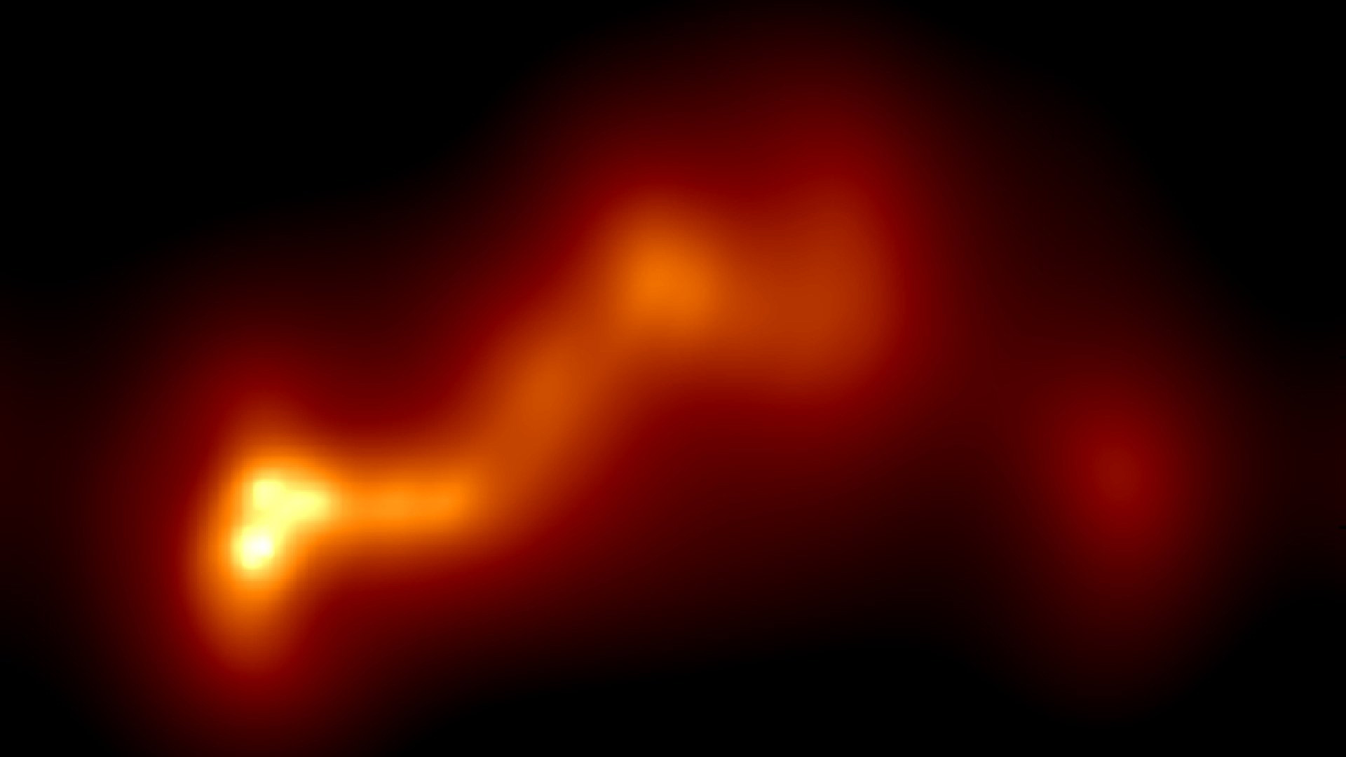 Blurry image showing a bright, glowing orange-yellow area with a wavy, elongated shape on a black background, resembling a heat or light source.