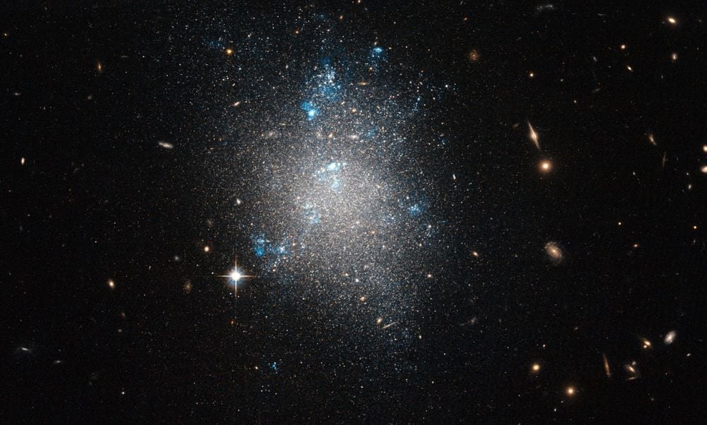 Dwarf galaxies like this one (NGC 5477) are satellites of larger galaxies like the Milky Way. New research examined 36 distant dwarf galaxies to see if they had their own, smaller satellites. The goal is a better understanding of how galaxies form and evolve in the Lambda Cold Dark Matter paradigm. Image Credit: ESA/Hubble &amp; NASA