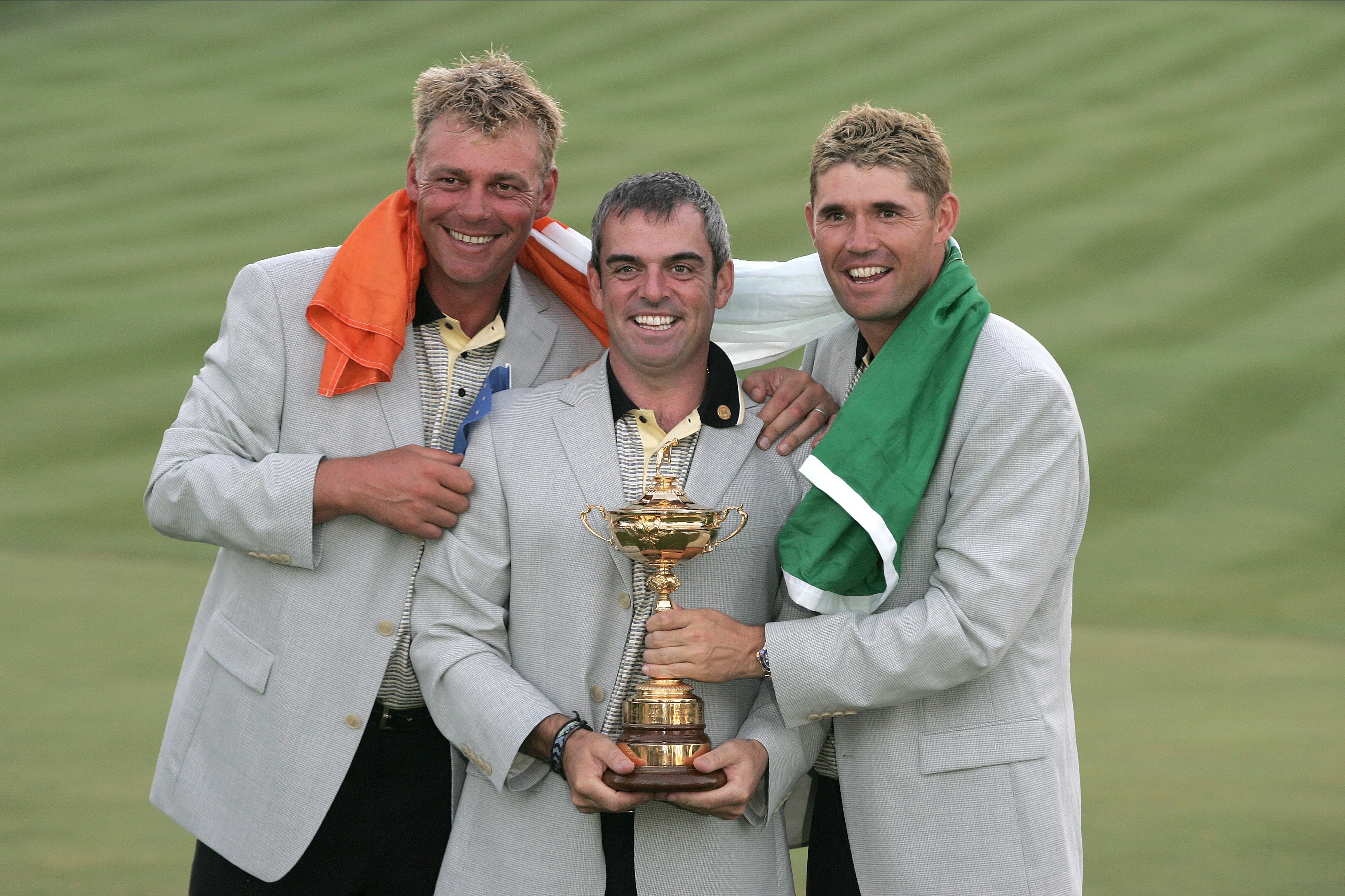 Three European golfers celebrating with the Ryder Cup trophy.
