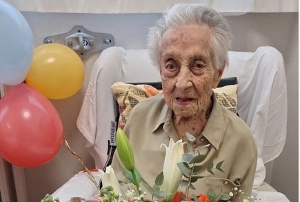 Maria Branyas Morera, the world's oldest person, with a bouquet of flowers and balloons.