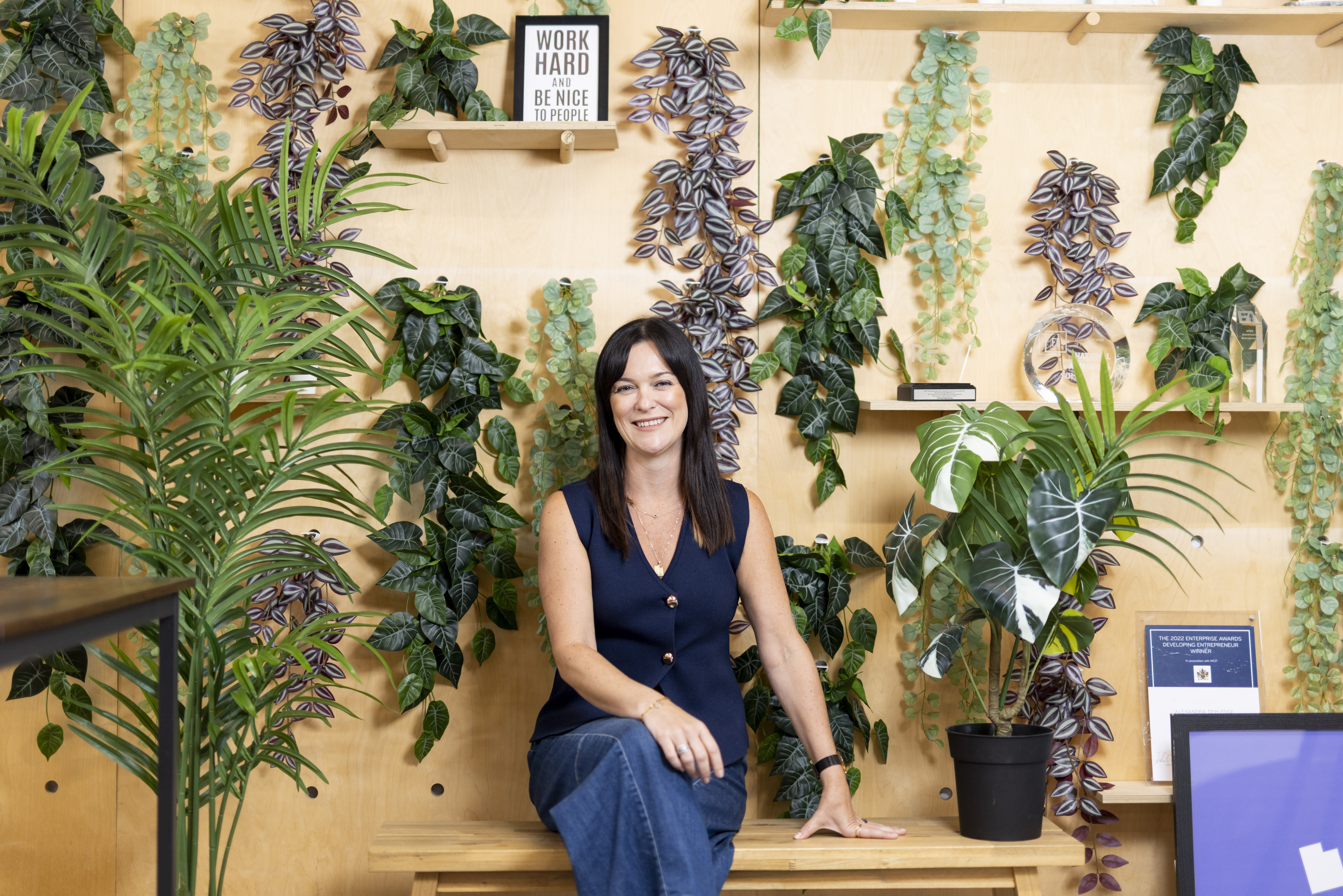 Alex Depledge, CEO of Resi, sitting in front of a wall of plants.
