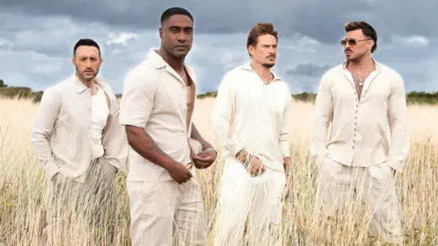 Owen James Vincent The members of Blue stand in a wheat field, each dressed in white. Antony and Simon look at the camera. Antony is frowning, Simon's face is neutral. Lee looks into the distance, angled to the left. Duncan looks into the distance, angled to the right and wearing sunglasses. The boys all wear necklaces, Duncan's has a visible cross on. Tattoos are visible on Duncan's chest, Simon's arm and there is a tattooed stencil of a lotus on Lee's neck. The men all have facial hair.