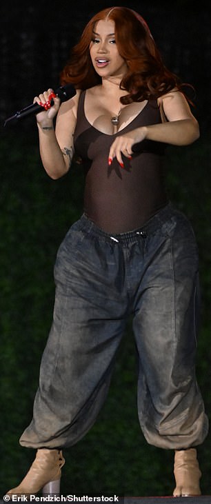 Wearing a fitted mahogany top with a set of maternity jeans that had an elastic waistband, Cardi strutted her stuff around the stage in a luxurious red wig