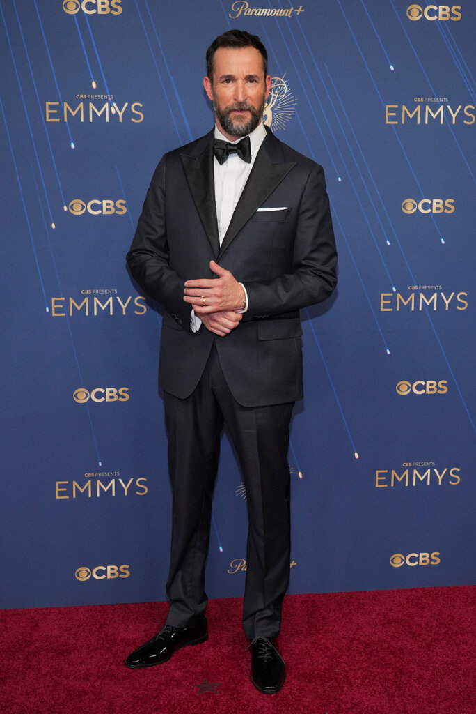 A man wears a black suit.