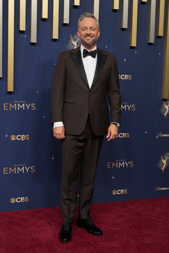 A man is wearing a brown tuxedo.