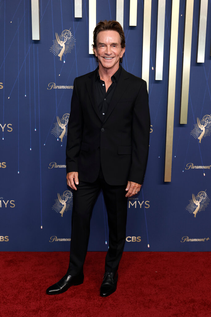 A man wears a black suit.